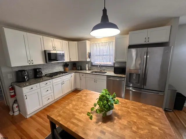 a kitchen with a refrigerator a sink a stove a microwave and cabinets