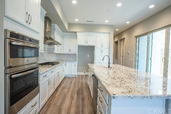 146 Spectacle Irvine, CA 92618 - Photo 15 of 57 a kitchen with granite countertop a sink stove and refrigerator
