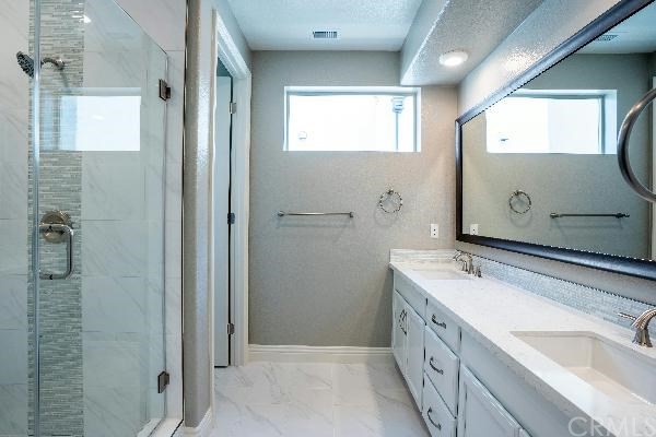 146 Spectacle Irvine, CA 92618 - Photo 33 of 57 a bathroom with a double vanity sink mirror and shower
