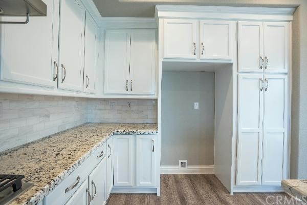 146 Spectacle Irvine, CA 92618 - Photo 38 of 57 a view of a kitchen with granite countertop white cabinets and a wooden floor