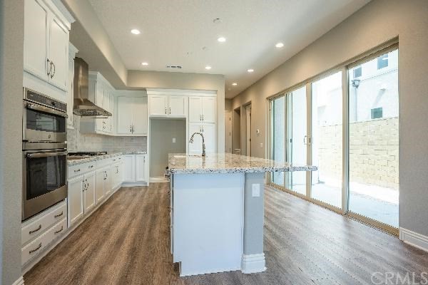 146 Spectacle Irvine, CA 92618 - Photo 39 of 57 a large kitchen with stainless steel appliances granite countertop a lot of counter space and wooden floors