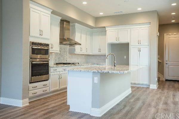 146 Spectacle Irvine, CA 92618 - Photo 9 of 57 a kitchen with stainless steel appliances granite countertop a stove and a refrigerator