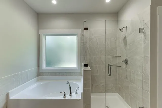 a white bath tub sitting next to a shower
