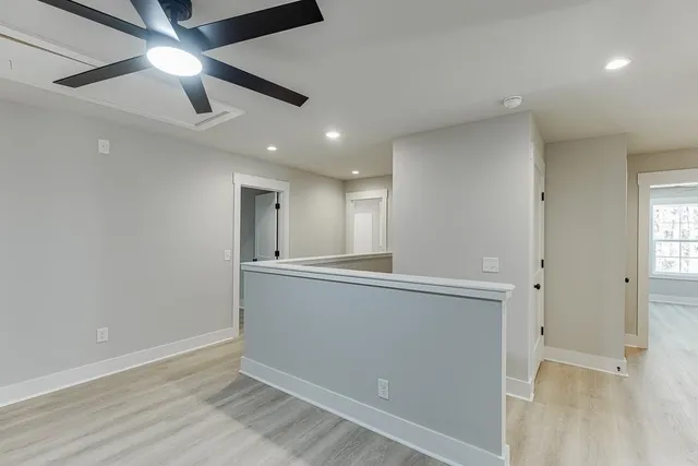 a view of an empty room with window and wooden floor