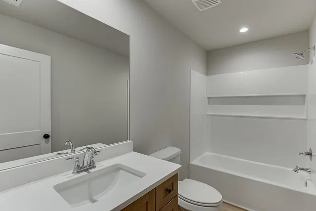 a bathroom with a sink toilet vanity and bathtub