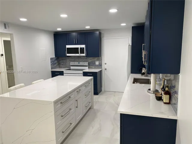a kitchen with stainless steel appliances a sink stove and microwave