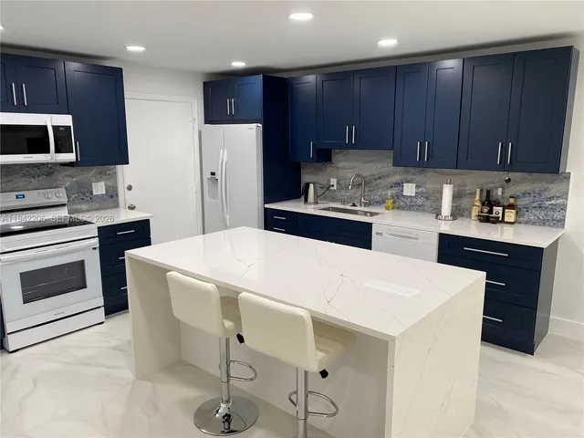 a kitchen with a sink a stove a refrigerator and cabinets
