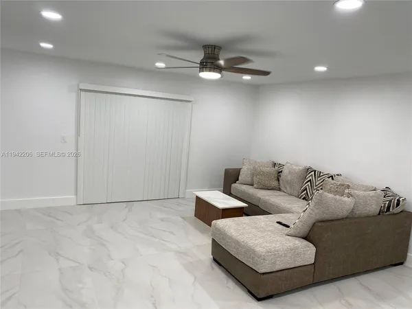 a living room with furniture and a ceiling fan