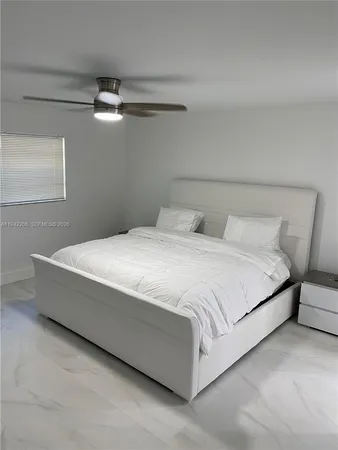 a bedroom with a bed and a ceiling fan