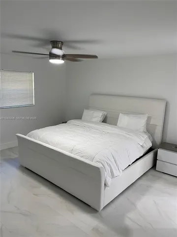 a bedroom with a bed and a ceiling fan
