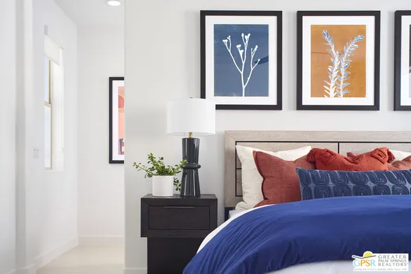 a bedroom with a bed and a painting on the wall