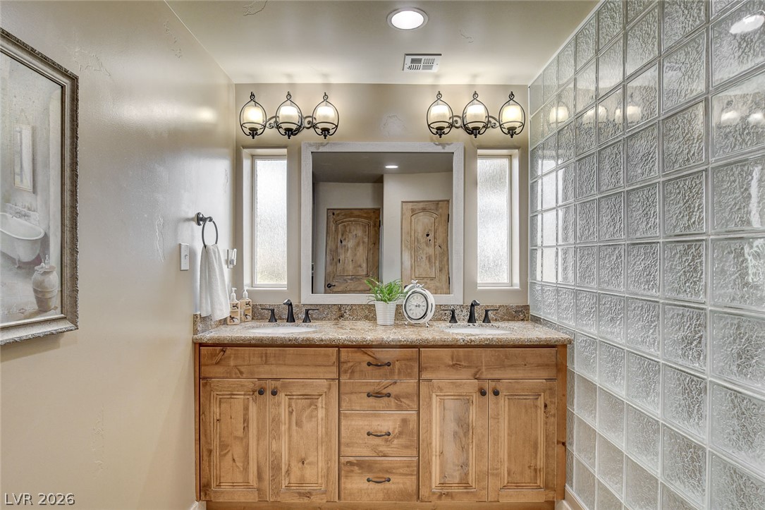 1950 Bowman Road Logandale, NV 89021 - Photo 37 of 81 Double vanity with stone counters and dual mirrors offers convenient bathroom functionality.