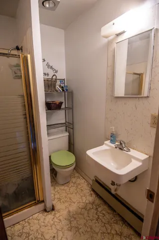 a bathroom with a sink a toilet and shower