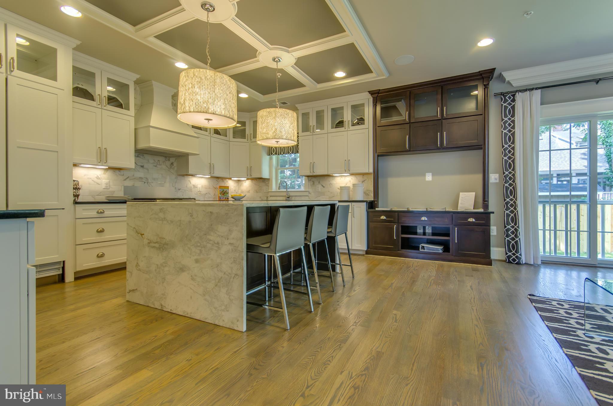 8106 Old Georgetown Road Bethesda, MD 20814 - Photo 14 of 30 a kitchen with stainless steel appliances kitchen island granite countertop a table chairs sink and cabinets