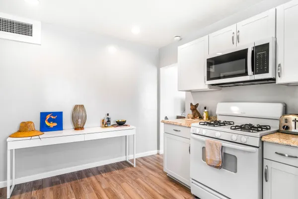 a kitchen with stainless steel appliances a white stove top oven and cabinets