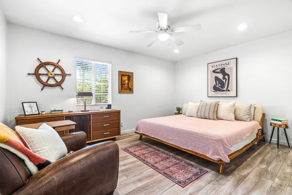 a bedroom with a bed and a painting on the wall