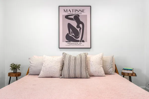 a bedroom with a bed and dresser with mirror