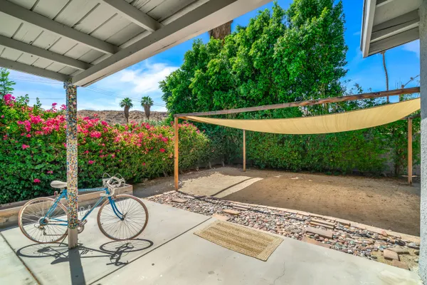 a patio with table and chairs and potted plants