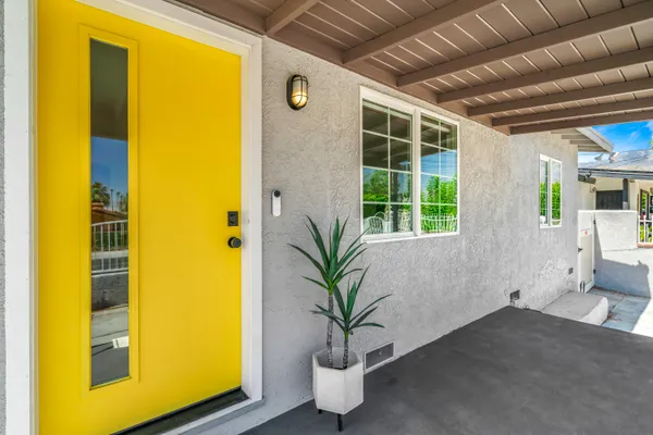 a potted plant sitting in front of a yellow house