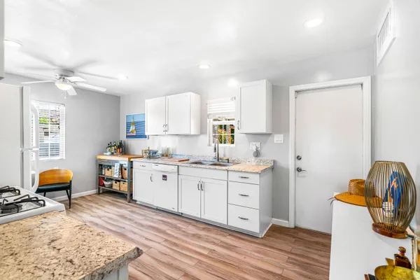 a kitchen with a sink and wooden floors