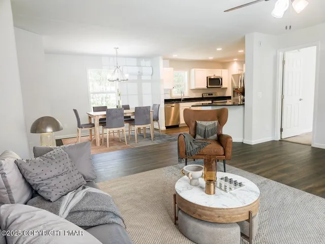 a living room with furniture and a dining table with kitchen view