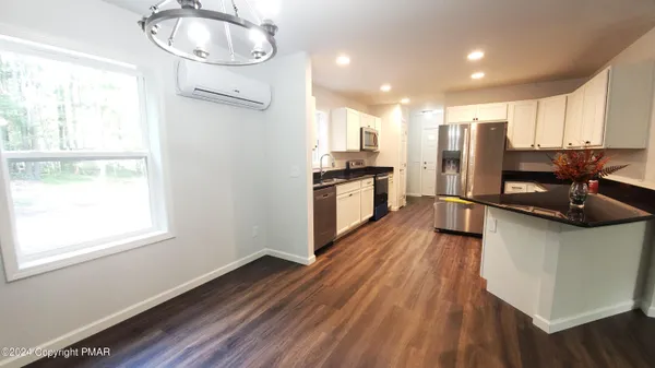 a kitchen with stainless steel appliances a stove a refrigerator a sink and wooden floor