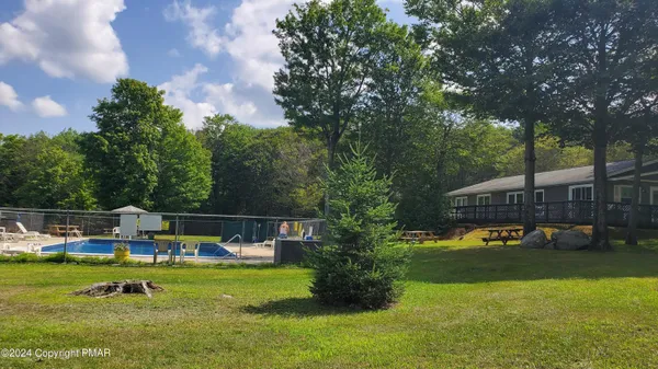 a view of a house with swimming pool and yard