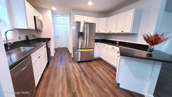 a kitchen with stainless steel appliances a stove a sink a refrigerator and cabinets