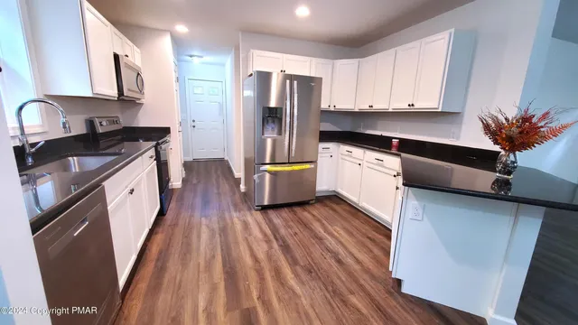 a kitchen with stainless steel appliances a stove a sink a refrigerator and cabinets