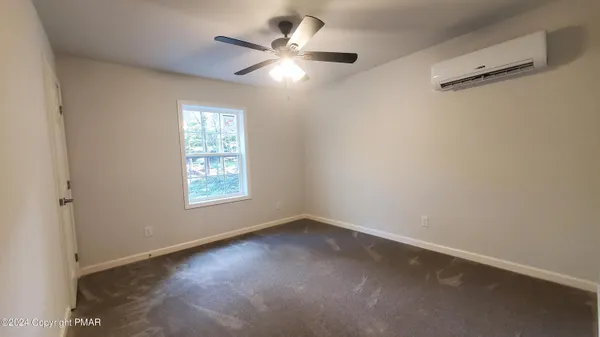 an empty room with a window and a fan