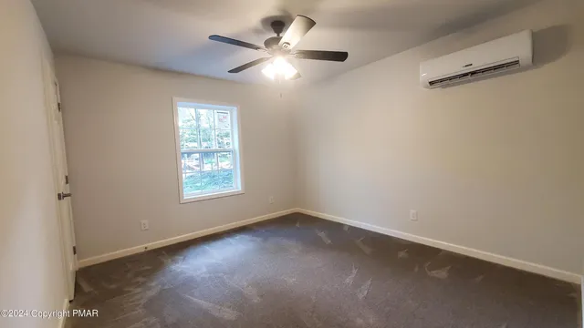 an empty room with a window and a fan