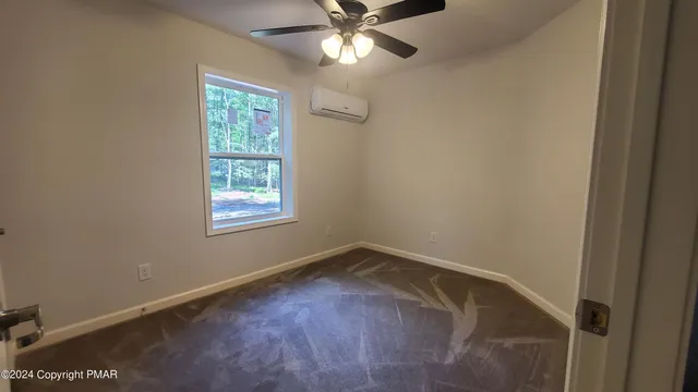 an empty room with a window and a fan
