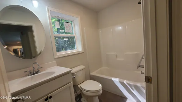 a bathroom with a granite countertop toilet a sink and a mirror