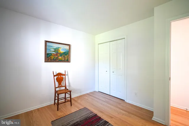 a view of a room with wooden floor and a workspace