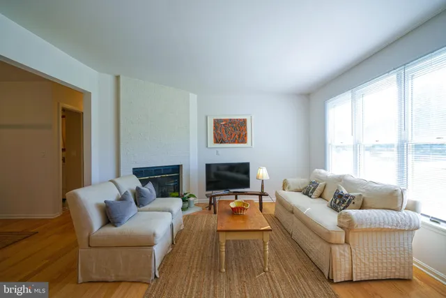 a living room with furniture wooden floor and a large window