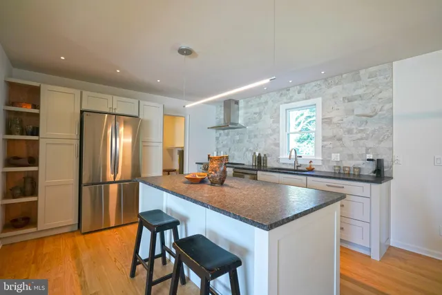a kitchen with stainless steel appliances granite countertop a sink a stove and a refrigerator