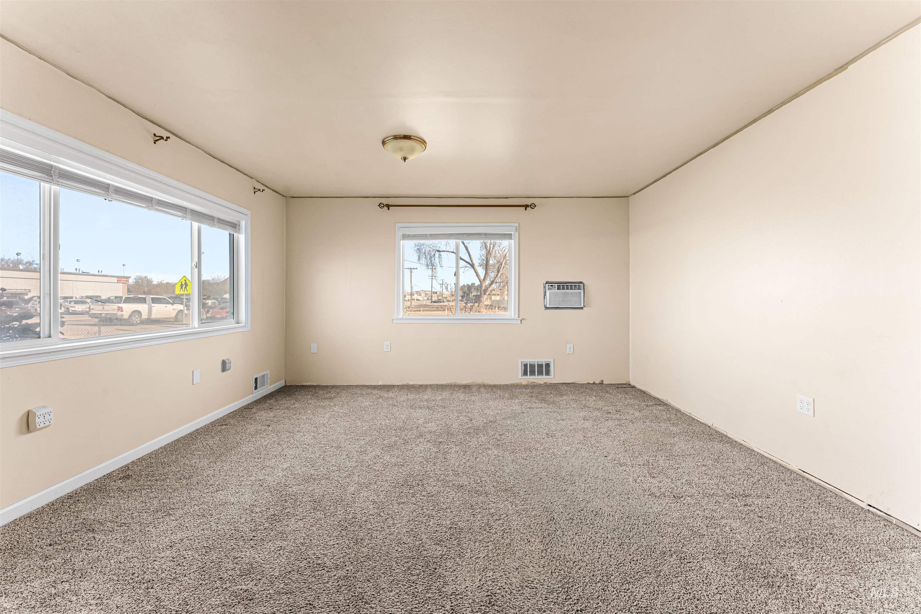 1115 Airbase Road Mountain Home, ID 83647 - Photo 27 of 32 Carpeted empty room with plenty of natural light and an AC wall unit