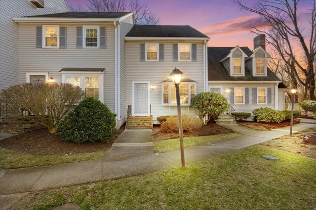 a front view of a house with a yard and potted plants
