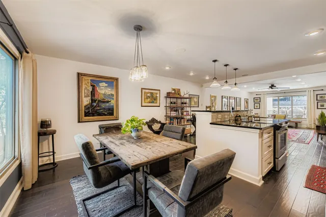 a view of a dining room and livingroom with furniture wooden floor a chandelier