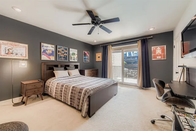 a bedroom with a bed flat screen tv and a large window