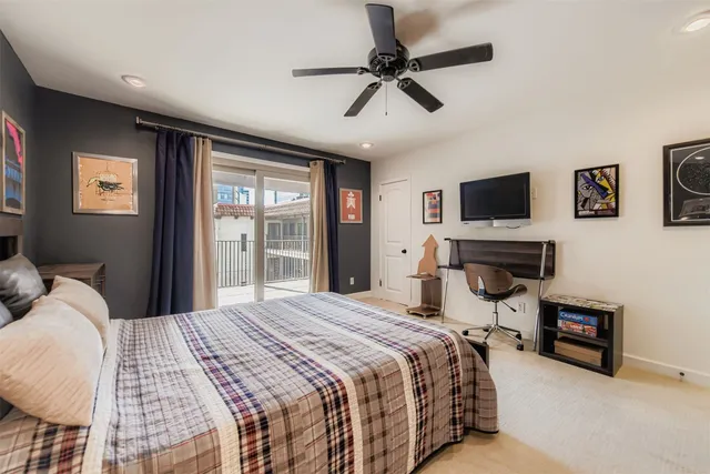 a bedroom with a bed flat screen tv and a window