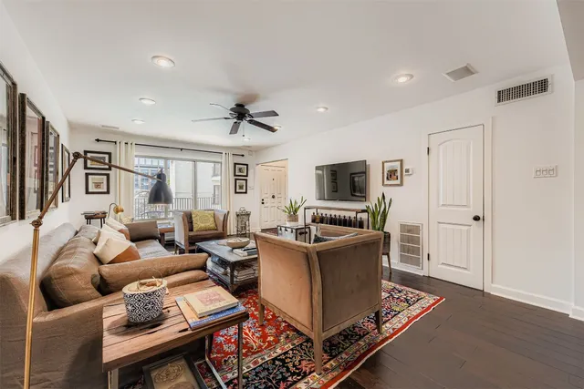a living room with furniture a flat screen tv and a window