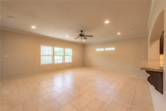 an empty room with windows and ceiling fan
