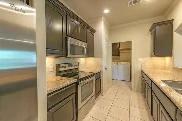 a kitchen with granite countertop cabinets and steel stainless steel appliances
