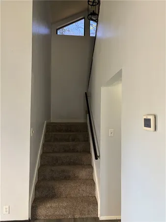 an empty room with a fan & a window