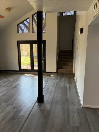 a view of a hallway with wooden floor and staircase