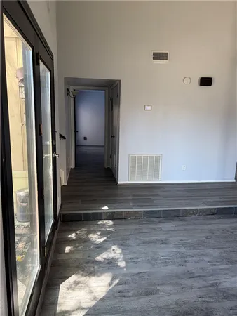 a view of a hallway with wooden floor and a large window