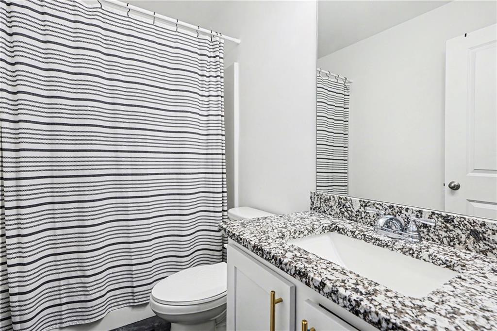 130 Serenity Way Conyers, GA 30013 - Photo 23 of 34 a bathroom with a granite countertop sink and a toilet