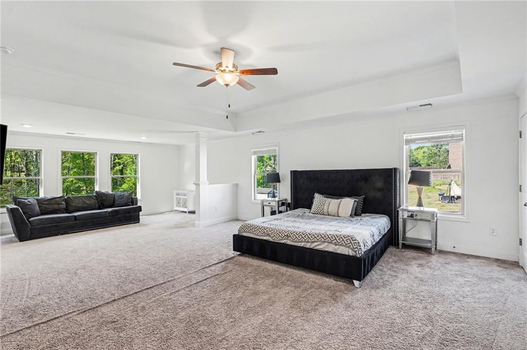 130 Serenity Way Conyers, GA 30013 - Photo 24 of 34 a spacious bedroom with a bed and a chandelier