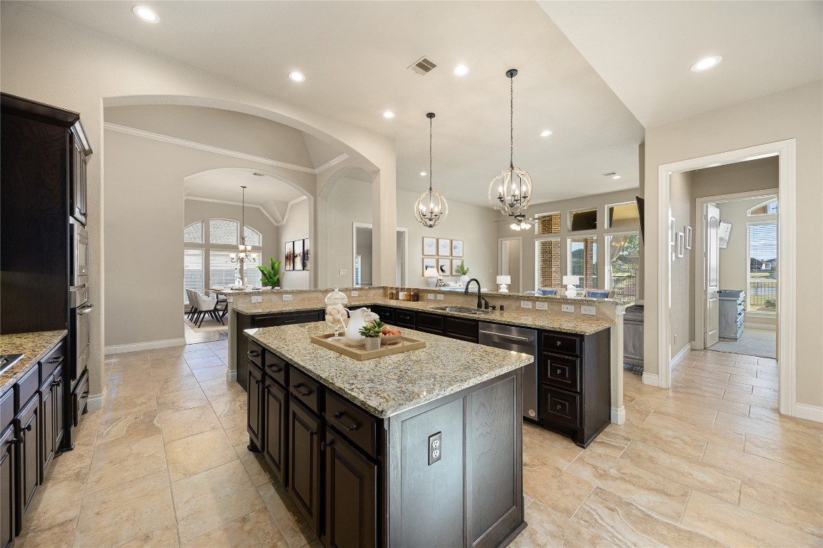 23211 Ruspino Shores Place Katy, TX 77493 - Photo 11 of 39 a kitchen with a stove center island a sink cabinets and wooden floor